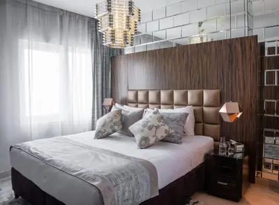 a bedroom with a large bed and a chandelier at Royal Club By RVHR, Bonnington Residential Tower - JLT in Dubai