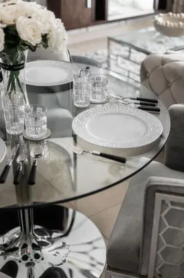 a glass table with plates and a vase of flowers at Royal Club By RVHR, Bonnington Residential Tower - JLT in Dubai