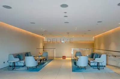 a waiting room with blue chairs and tables at Modern 1BR Oasis in Prime Location, Book Now by Deluxe Holiday Homes in Dubai