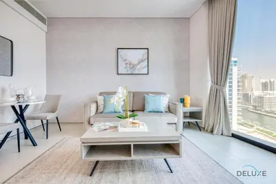 a living room with a couch and a table at Modern 1BR Oasis in Prime Location, Book Now by Deluxe Holiday Homes in Dubai