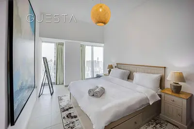 a bedroom with a bed and a large window at Cayan Tower, Dubai Marina in Dubai