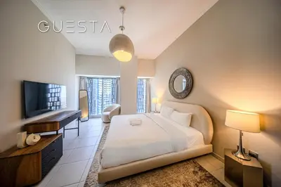 a bedroom with a large bed and a television at Cayan Tower, Dubai Marina in Dubai
