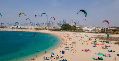 a group of people on a beach flying kites at Jumeirah Beach Villa in Dubai