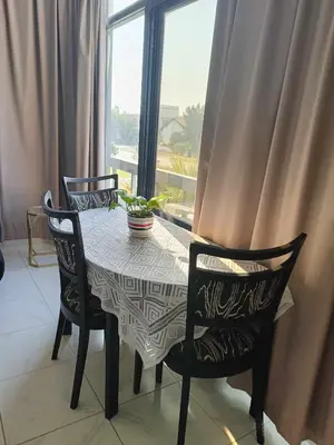 a dining room table with two chairs and a window at Jumeirah Beach Villa in Dubai
