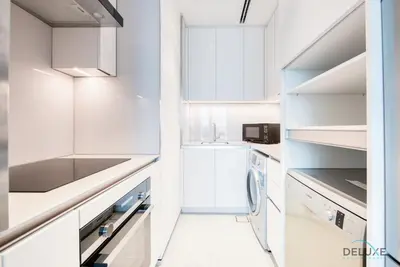 a white kitchen with white cabinets and a sink at Posh 1BR at The Address Residences in JBR by Deluxe Holiday Homes in Dubai