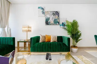 a living room with a green couch and a table at Dream Inn Apartments - Mina by Azizi in Dubai