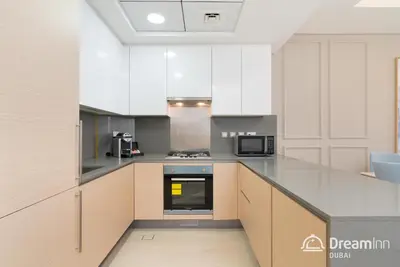 a large kitchen with white cabinets and appliances at Dream Inn Apartments - Mina by Azizi in Dubai