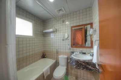 a bathroom with a tub and a sink and a toilet at La Villa Najd Hotel Apartments in Dubai