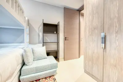 a bedroom with a bed and a chair at Palm Jumeirah Luxury Apartments by Propr in Dubai