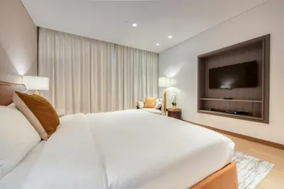 a bedroom with a large white bed and a flat screen tv at Palm Jumeirah Luxury Apartments by Propr in Dubai