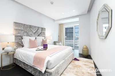 a bedroom with a large bed and a large window at Dream Inn - Damac Heights by Fendi in Dubai