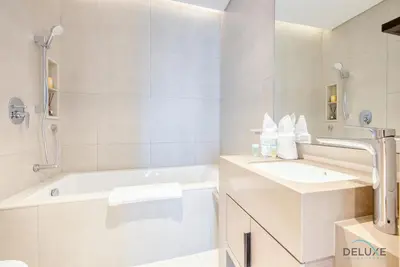 a white bathroom with a tub and a sink at Captivating 1BR at The Address Residences in JBR by Deluxe Holiday Homes in Dubai