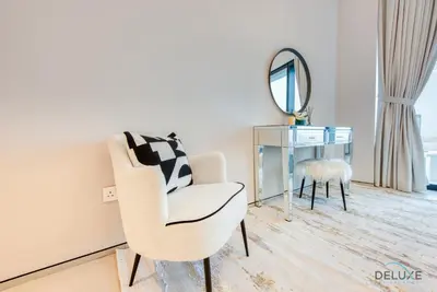 a living room with a chair and a mirror at Captivating 1BR at The Address Residences in JBR by Deluxe Holiday Homes in Dubai