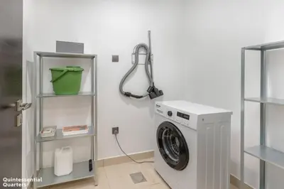 a washing machine in a laundry room with a shelf at Peaceful Oasis 3BR+kids, 7 min walk to Dubai Mall in Dubai
