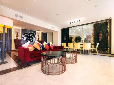 a living room with a red couch and a table at Elan Murjan Rimal Suites, Sea in 3 min walk! 6 Bedrooms & Hall, Massive Layout in Dubai