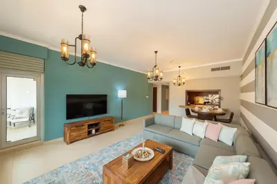 a living room with a couch and a tv at One Bedroom in Burj Views by Radiance Vacation Stays in Dubai