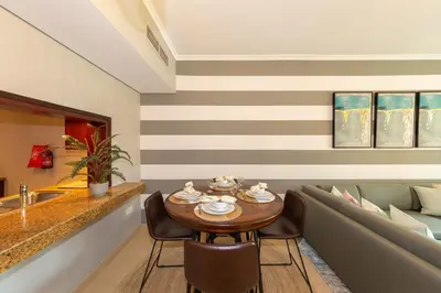 a dining room with a table and chairs and a couch at One Bedroom in Burj Views by Radiance Vacation Stays in Dubai