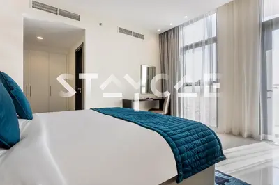 a bedroom with a bed with a blue blanket on it at Staycae Holiday Homes - Celestia in Dubai