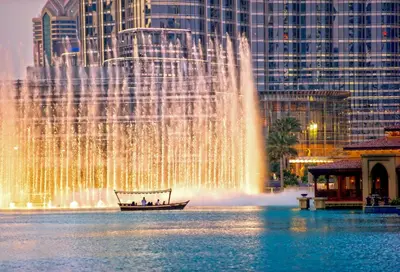 a boat in front of a fountain in a city at Rove City Walk in Dubai