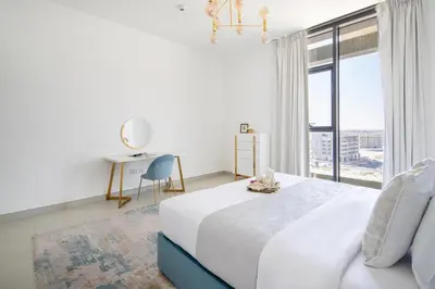a white bedroom with a bed and a large window at Frank Porter - The Pulse Residences in Dubai