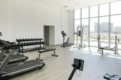 a gym with several treadmills and exercise machines at Frank Porter - The Pulse Residences in Dubai