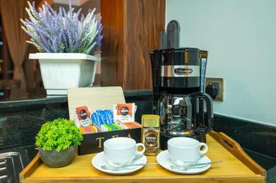 a coffee maker and two cups on a wooden tray at Burj Residence by Radiance Vacation Stays in Dubai