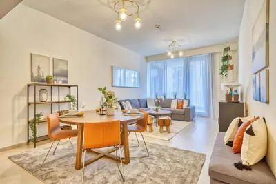 a living room with a table and chairs and a couch at Incredible Views From This Classy Apt With Terrace in Dubai