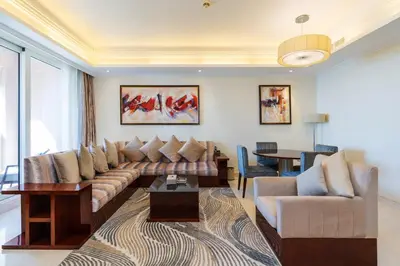 a living room with a couch and a table at Royal Club By RVHR, Grandeur Residence Crescent Palm Jumeirah in Dubai