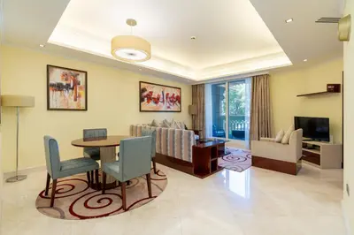 a living room with a table and a couch at Royal Club By RVHR, Grandeur Residence Crescent Palm Jumeirah in Dubai