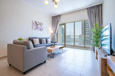 a living room with a couch and a tv at RH- Prime Location, Spacious 2BR, walk to Dubai Mall in Dubai