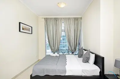 a bedroom with a large bed and a window at Steps Away From the Beach & Entertainment Hubs 1BR Unit, Torch Tower, Dubai Marina by Deluxe Holiday Homes in Dubai