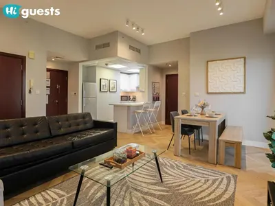 a living room with a black couch and a table at HiGuests - Artistic Waterfront Apt, Perfect for Beach Lovers in Dubai