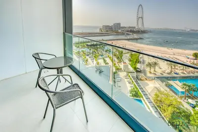 a balcony with two chairs and a view of the beach at Pristine 2BR with Assistants Room at The Address Residences in JBR by Deluxe Holiday Homes in Dubai