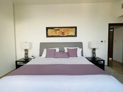 a bedroom with a large bed with purple pillows at Beautiful apartment with amazing sea views in Dubai