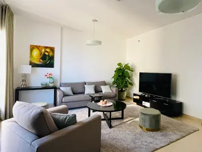 a living room with a couch and a tv at Beautiful apartment with amazing sea views in Dubai