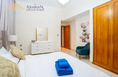 a bedroom with a white bed with a blue bag on it at New Arabian Trident Waterfront 3 BR plus maid in Dubai