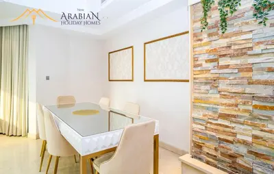 a dining room with a table and chairs and a brick wall at New Arabian Trident Waterfront 3 BR plus maid in Dubai