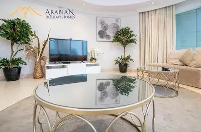 a living room with a table and a tv at New Arabian Trident Waterfront 3 BR plus maid in Dubai