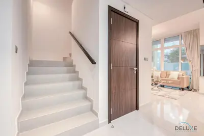 a staircase with a wooden door in a house at Delightful 3BR Townhouse at DAMAC Hills 2 Dubailand by Deluxe Holiday Homes in Dubai