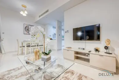a living room with a tv and a glass table at Delightful 3BR Townhouse at DAMAC Hills 2 Dubailand by Deluxe Holiday Homes in Dubai
