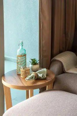 a table with a bottle on it next to a chair at Frank Porter - Aura by Azizi in Dubai