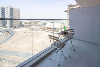 a chair on a balcony with a view of a city at Frank Porter - Aura by Azizi in Dubai