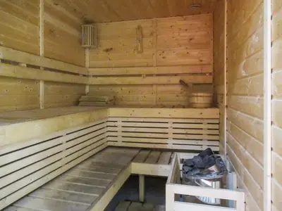 an empty wooden sauna with a bench in it at Frank Porter - Aura by Azizi in Dubai