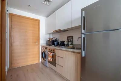 a kitchen with a refrigerator and a washer at Frank Porter - Aura by Azizi in Dubai