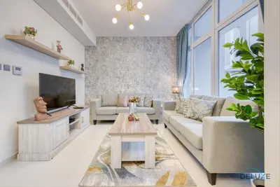 a living room with a couch and a tv at Opulent 3BR Townhouse at DAMAC Hills 2 Dubailand by Deluxe Holiday Homes in Dubai