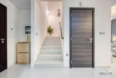 a hallway with a door leading to a staircase at Opulent 3BR Townhouse at DAMAC Hills 2 Dubailand by Deluxe Holiday Homes in Dubai