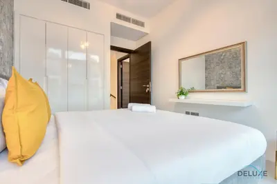 a bedroom with a large white bed and a mirror at Opulent 3BR Townhouse at DAMAC Hills 2 Dubailand by Deluxe Holiday Homes in Dubai