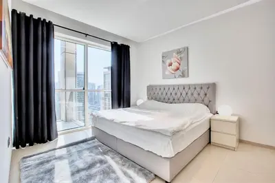 a bedroom with a bed and a large window at 1 BD in West Avenue tower Dubai Marina in Dubai