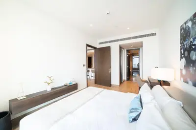 a bedroom with a large white bed and a living room at Luton Vacation Homes - Marina View & Luxury 1BR - Jumeirah Living Marina Gate Tower 3 - 54AB49AB36AB in Dubai