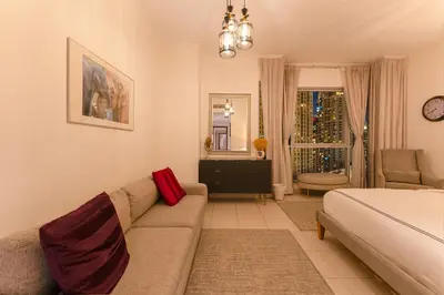 a living room with a couch and a bed at Spectacular Burj & Fountain View - Luxurious 3 Bedrooms & Maids room - The Residences in Dubai